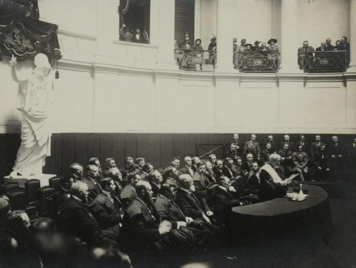 Rector Peter Hoffmann speecht in de Aula op de openingszitting van de Vlaamse Hogeschool op 24 oktober 1916. Op de achtergrond kijkt Minerva toe  (Collectie Universiteitsbibliotheek Gent)